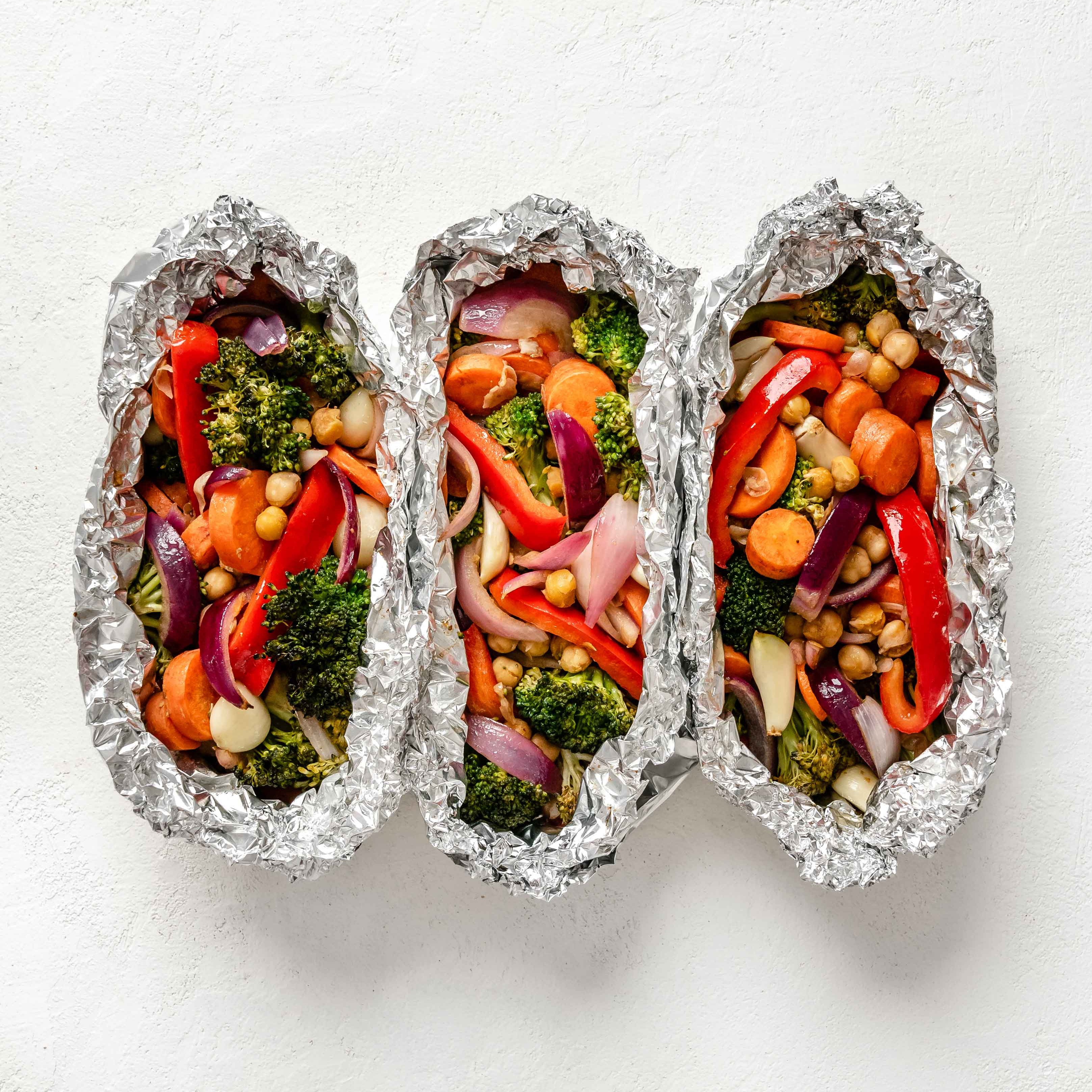 Red peppers, carrots, broccoli, onions, and garbanzo beans wrapped in foil and baked